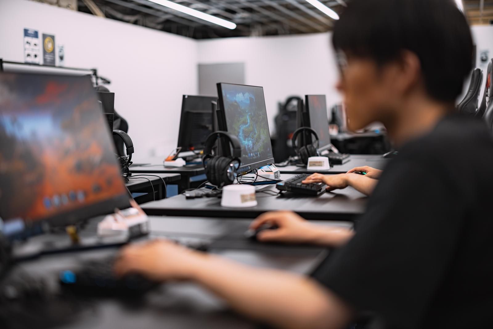 モニターとキーボードが並ぶPC席でプレイする様子（他施設のイメージ）